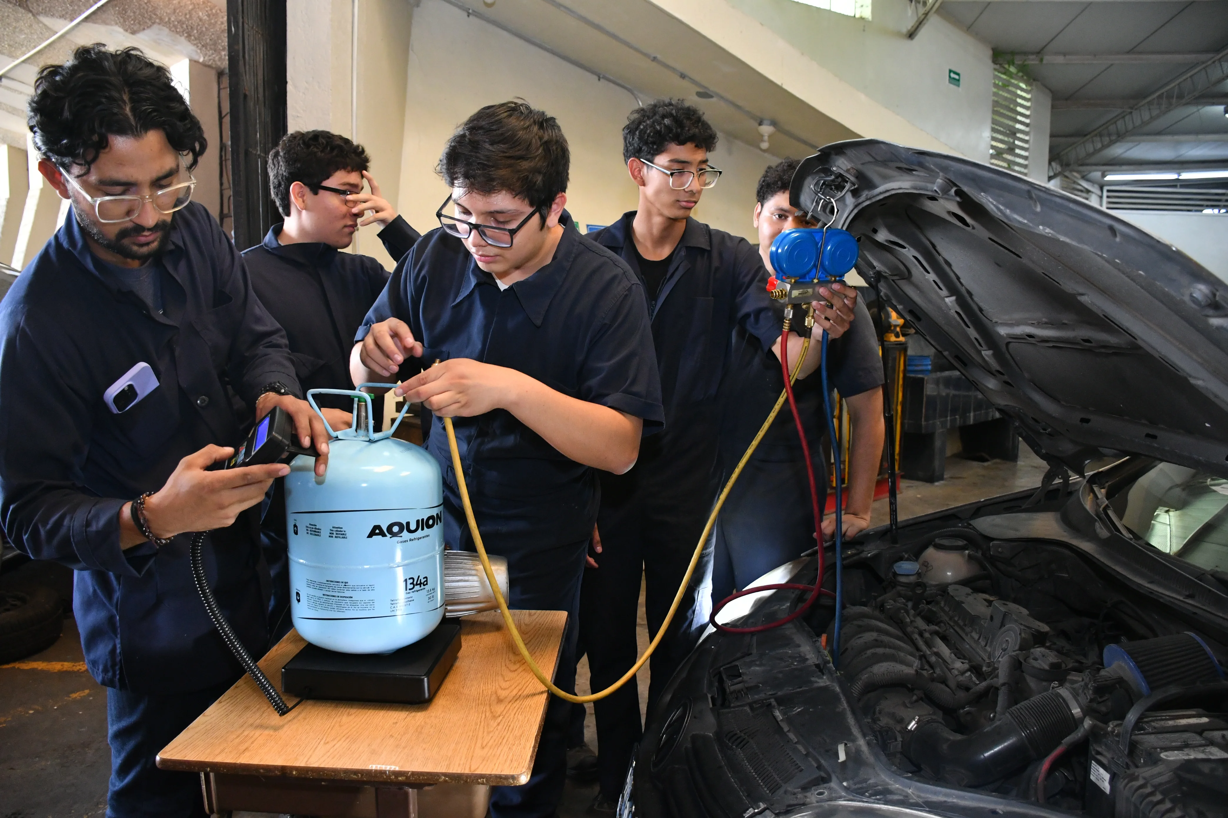 Estudiantes de Mantenimiento Automotriz trabajando en un vehículo