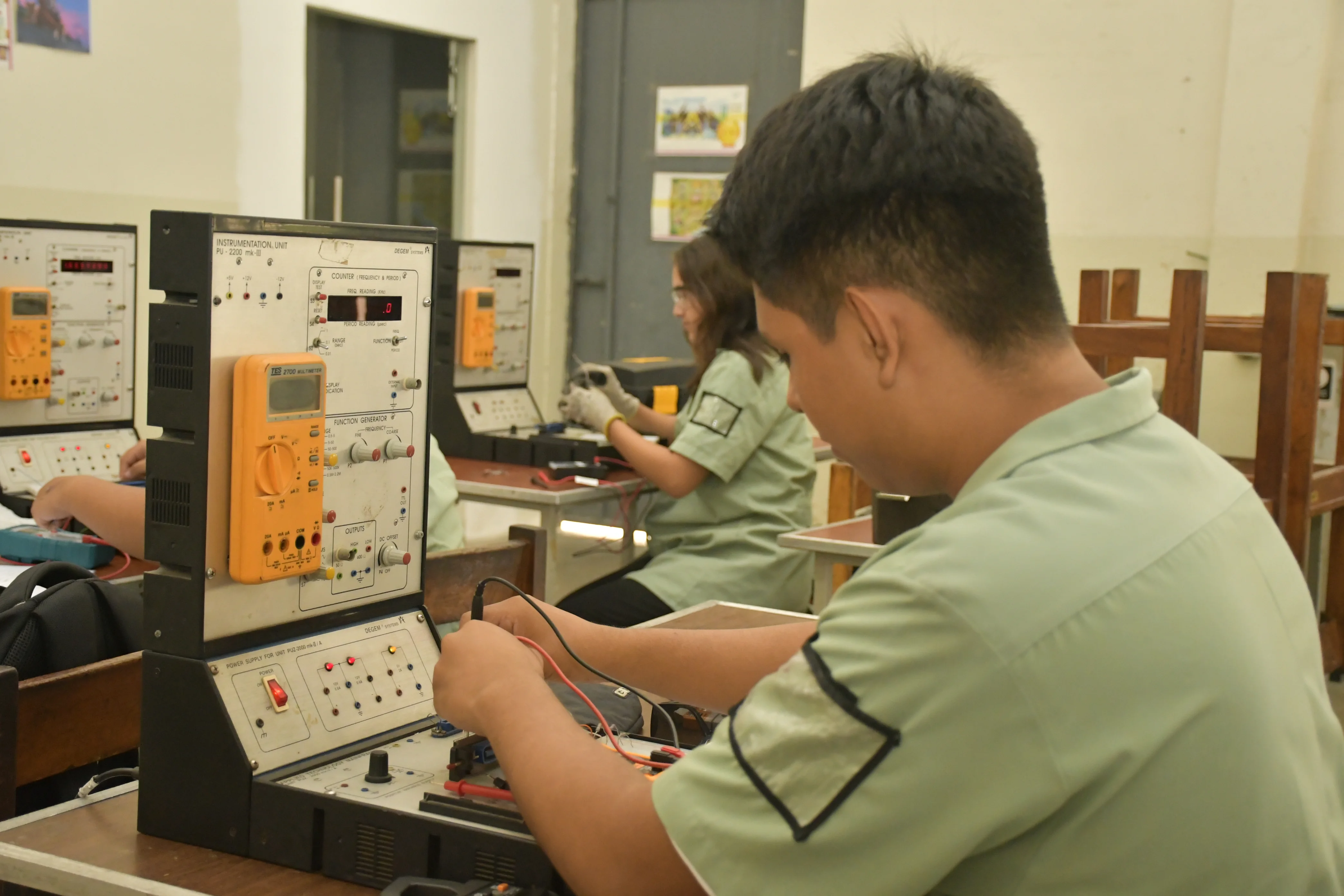 Estudiantes de Electromecánica trabajando con maquinaria
